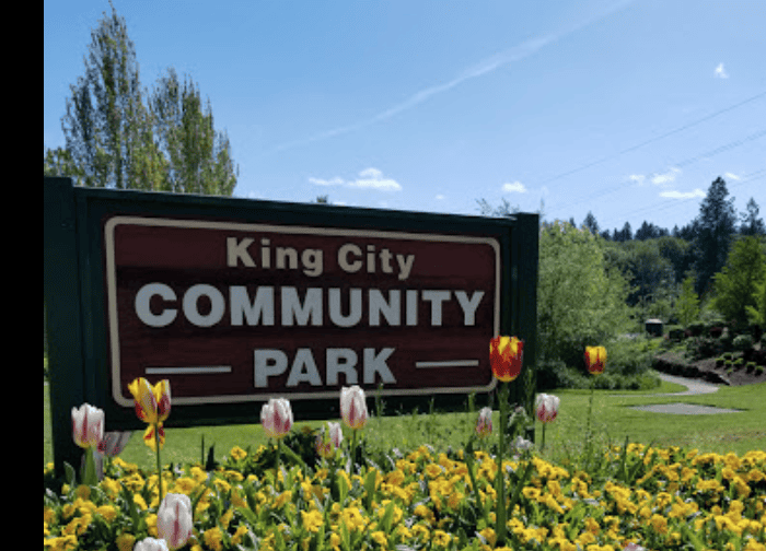 King City Community Park sign surrounded by colorful flowers and lush greenery, creating a welcoming outdoor space perfect for family gatherings, outdoor activities, and community events.